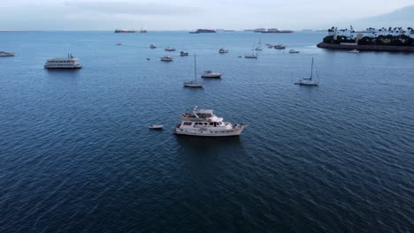 a beautiful aerial drone shot, flying over a white boat in long beach, california