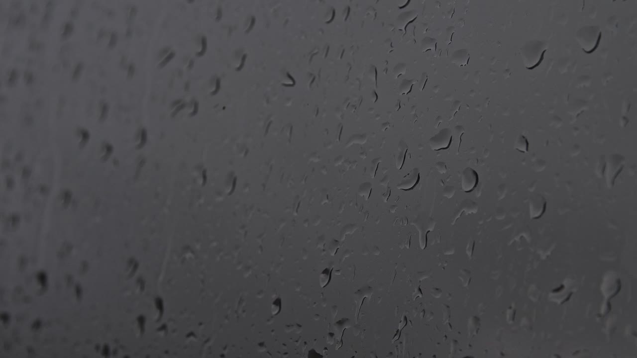 gotas de agua fluyen por el vidrio en la lluvia