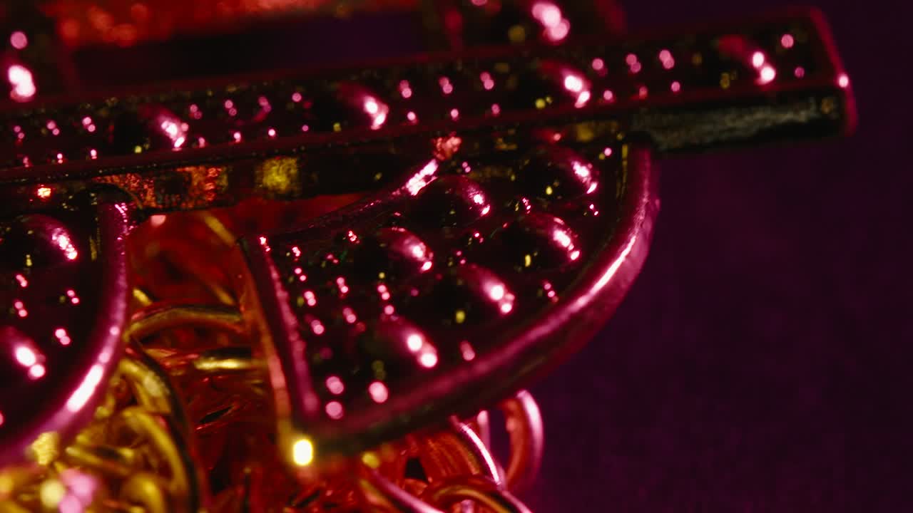 緑と紫に点滅する金のドルマークのネックレスの超接写