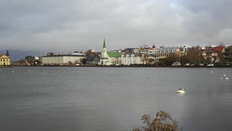 Hermoso-Paisaje-Urbano-De-Reykjavik-Islandia-Junto-Al-Lago-En-Una-Tarde-Nublada---Plano-Amplio