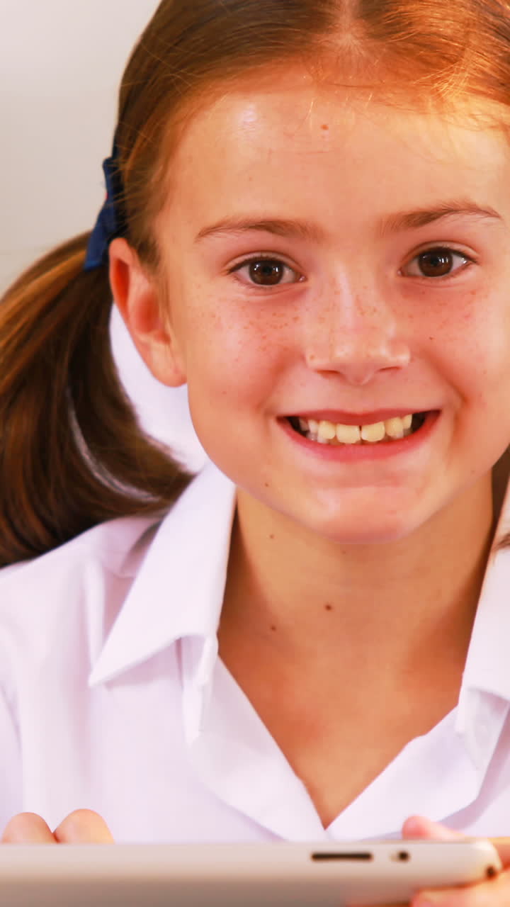Schoolgirl using digital tablet in classroom