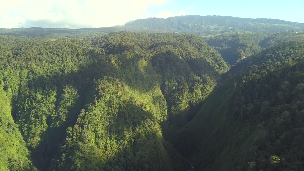 lento y suave drone sobre montañas verdes exuberantes iluminación dramática disparo majestuoso
