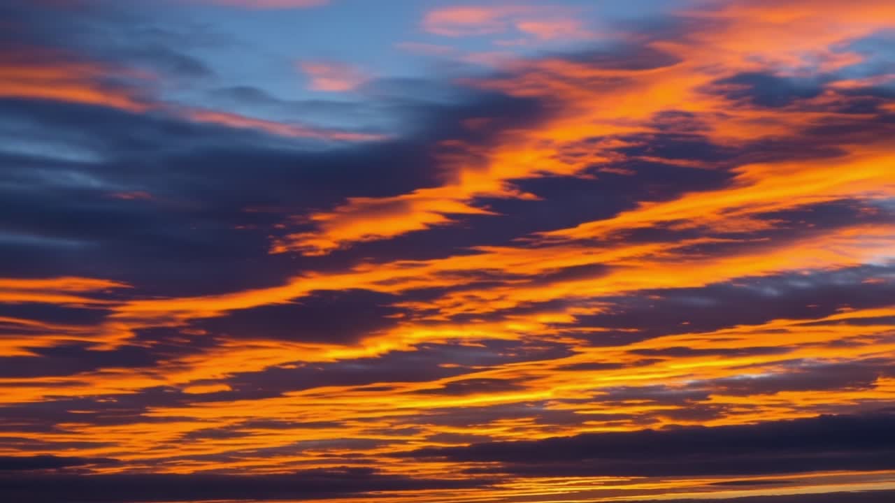 A Breathtaking Display of Colors in the Sky: Captivating Sunset with Fiery Oranges and Deep Purples, Perfectly Framed by Striking Silhouettes of Clouds
