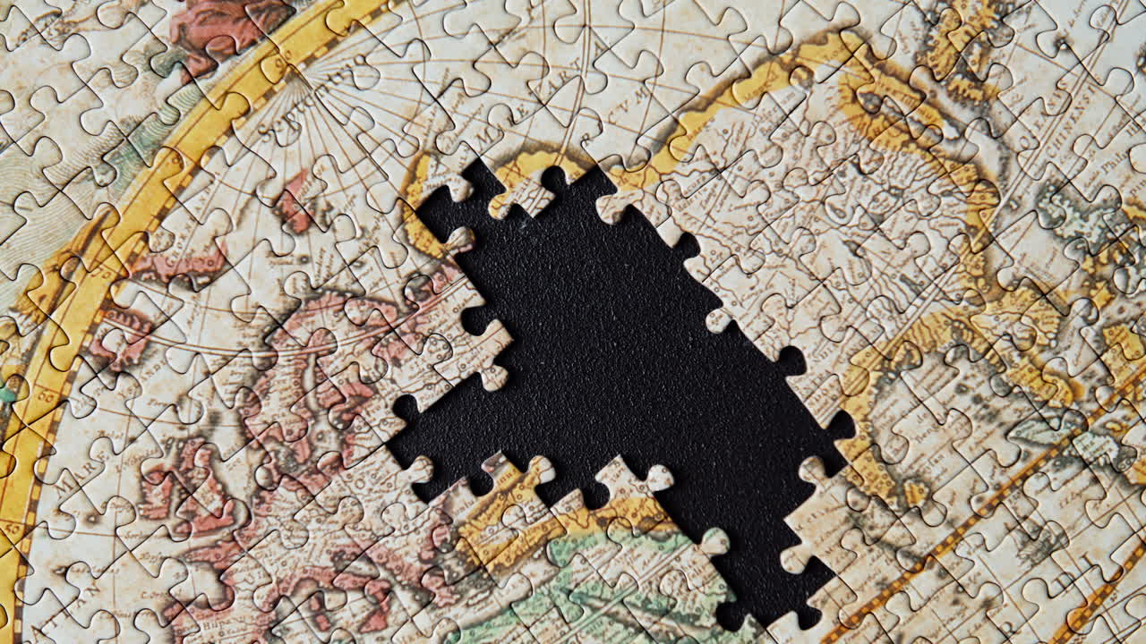 Fingers placing cardboard segment on surface assembling classic puzzle closeup