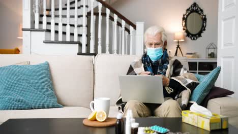 anciano sentado en la habitación en casa y chateando por video en la computadora portátil