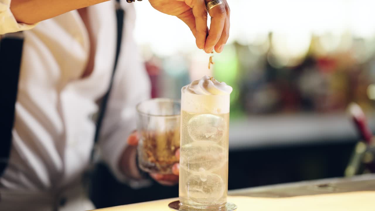 Bartender Garnishing a Refreshing Cocktail with Foam and Ice