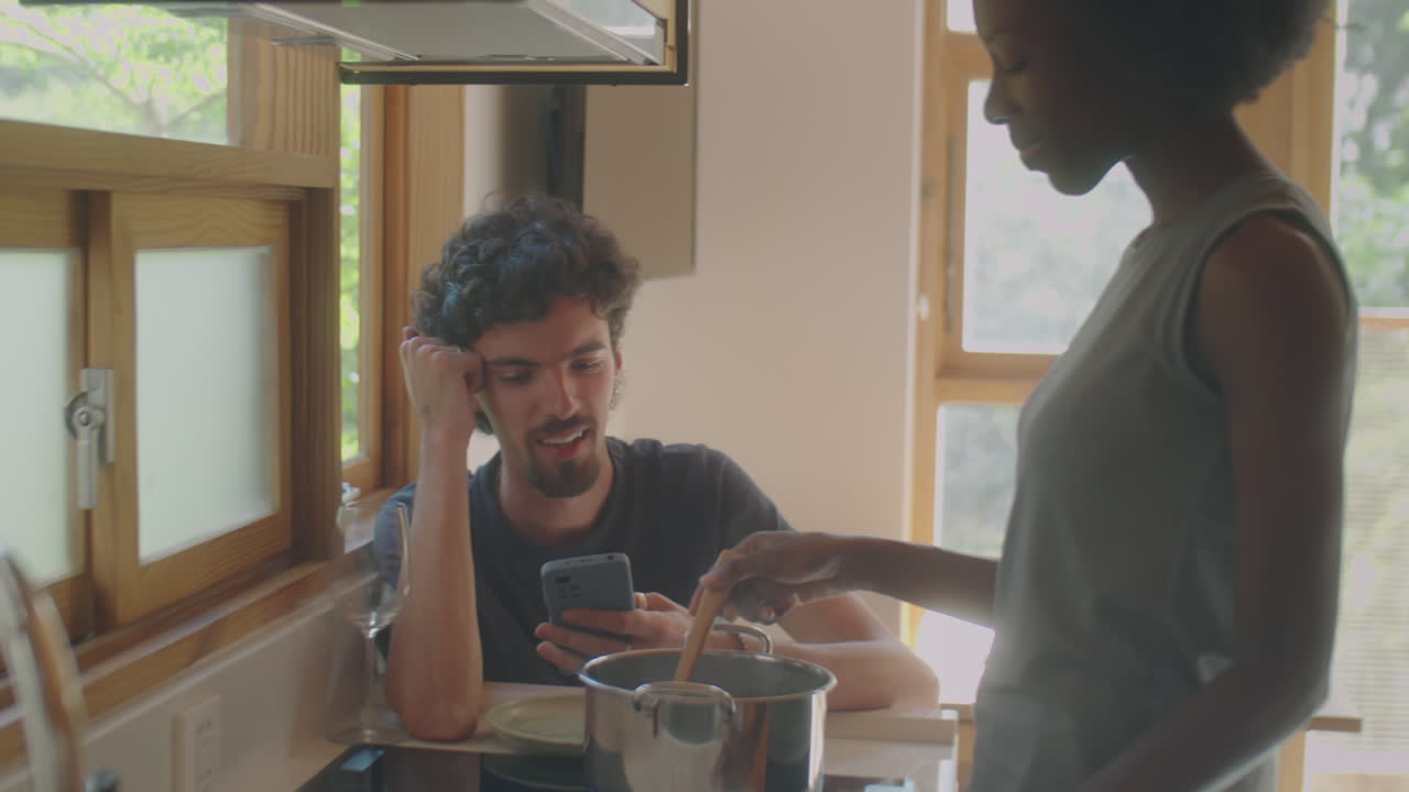 Woman Cooking Dinner and Talking with Husband
