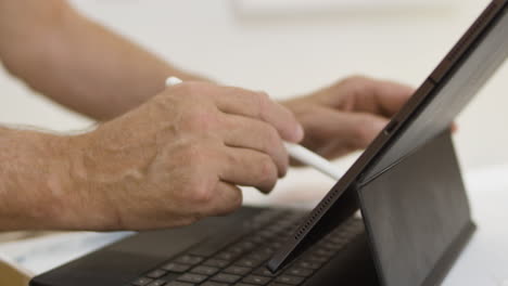 Elderly-man-using-iPad-tablet-with-stylus-and-learning-new-technology