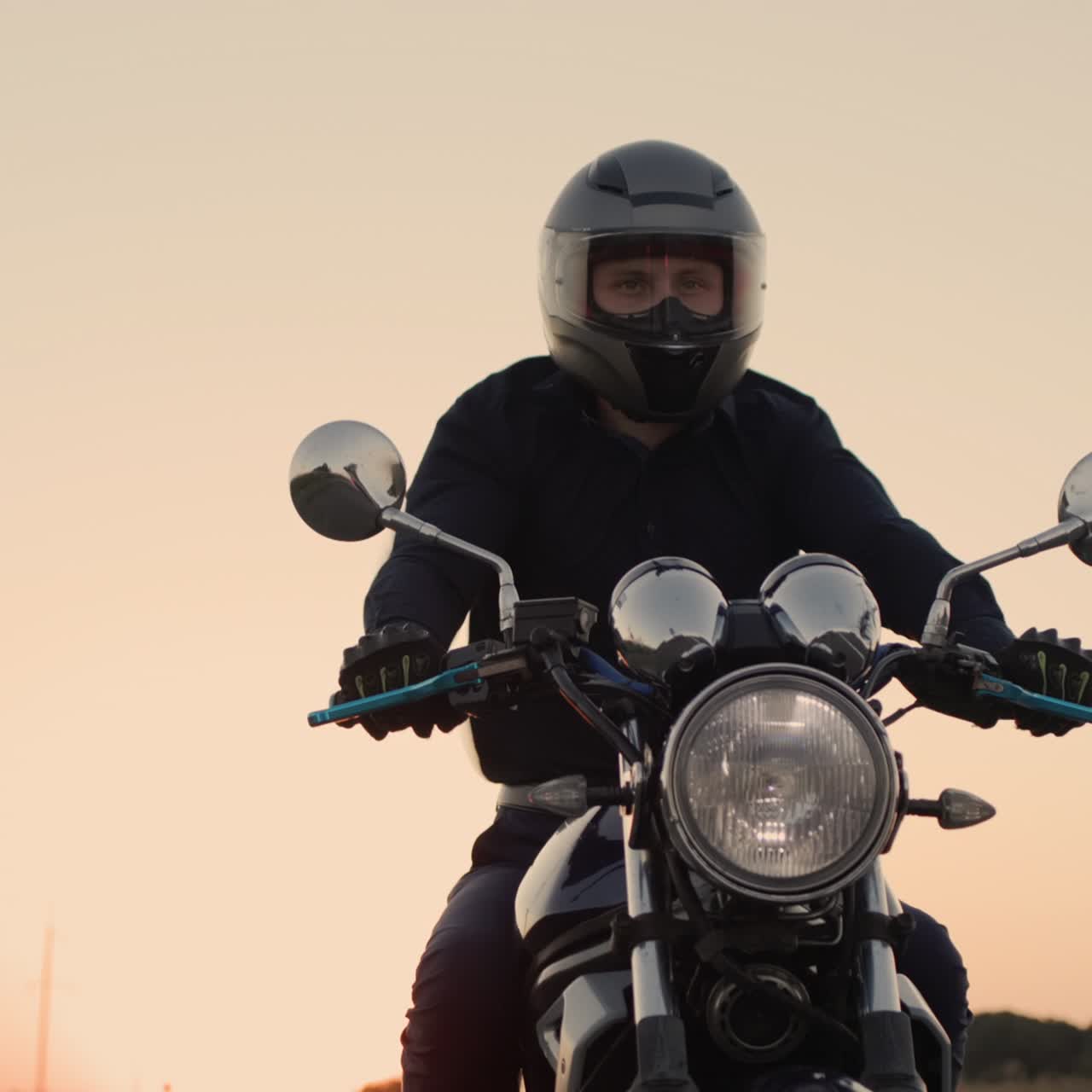 motociclista en una chaqueta negra monta al atardecer 1