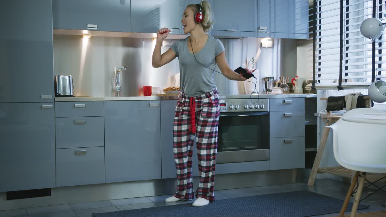 Donna che canta e balla in cucina