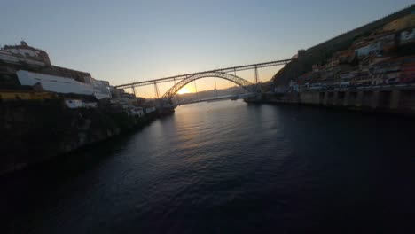 low-level fpv shot near water surface of douro river by ribeira neighborhood of porto, portugal