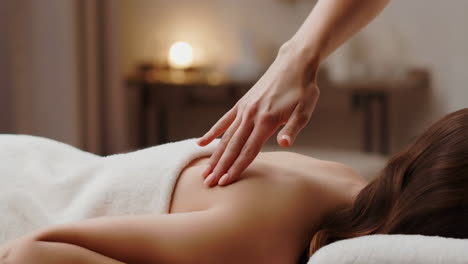 a close-up shot of a professional giving a back massage at a spa