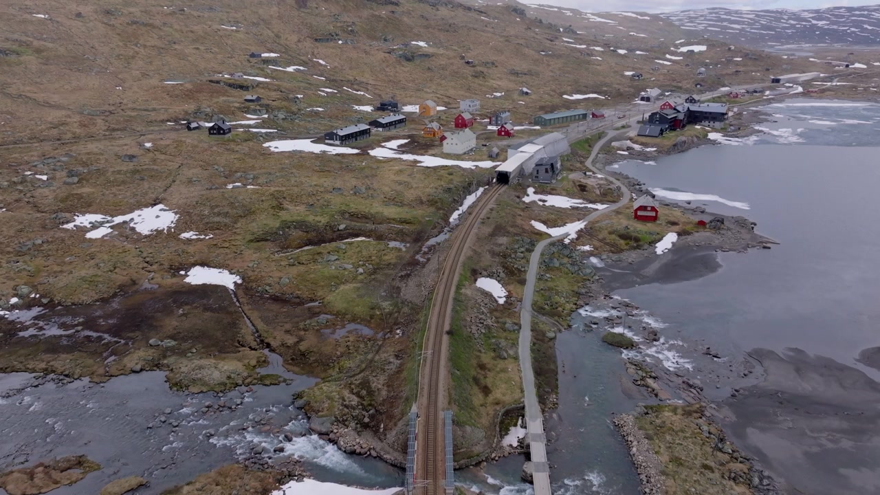 Ripresa aerea cinematografica di Finse, un remoto insediamento montano lungo la ferrovia di Bergen, catturato nel cuore degli altipiani norvegesi.