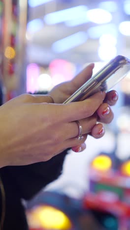 close-up of hands holding a smartphone in a brightly lit, blurry background
