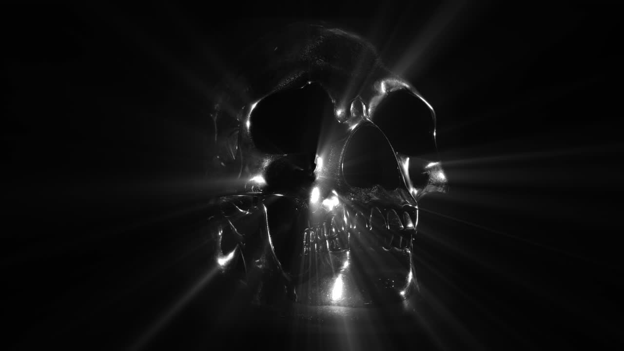 cráneo de metal plateado sobre fondo negro, girando y emitiendo rayos de luz