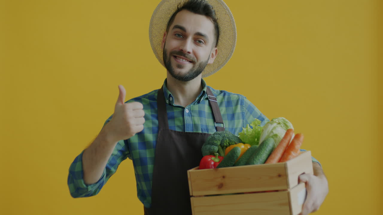 Contadino che tiene una cassa di legno piena di verdure fresche