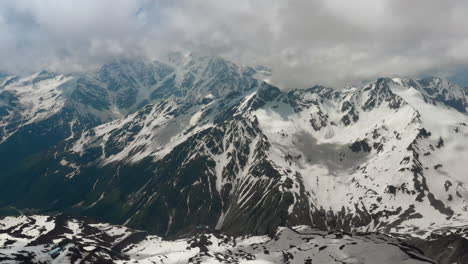 vuelo aéreo a través de nubes montañosas sobre hermosos picos nevados de montañas y glaciares.