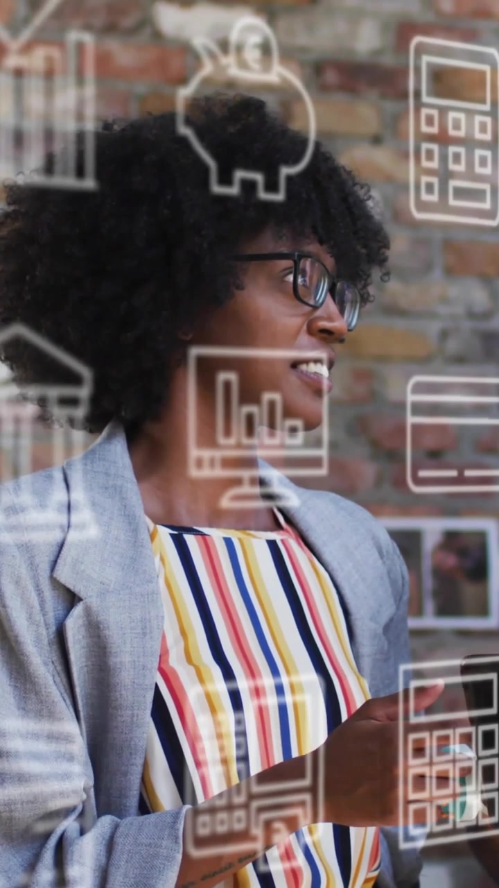 Vertical video: Woman pointing and tapping phone in office, explaining finance as icons floating