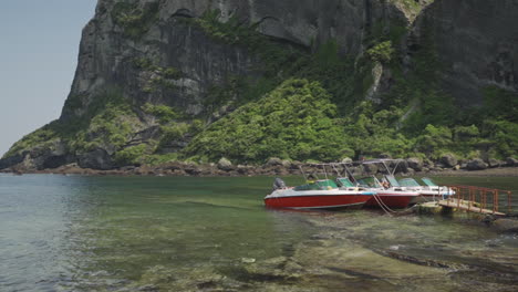 boats docked near a cliffside cove