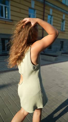 woman with curly hair in green dress outdoors