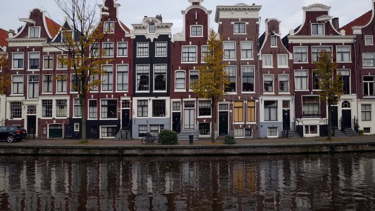 Affascinante fila di edifici storici lungo un tranquillo canale, che mette in mostra dettagli architettonici e riflessi nell'acqua, creando una pittoresca scena urbana