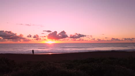 uhd hawaii kauai static of couple in distance on beach watching partly cloudy sunrise.  part five of five, also available as five clips in timelapse or hybrid timelapse