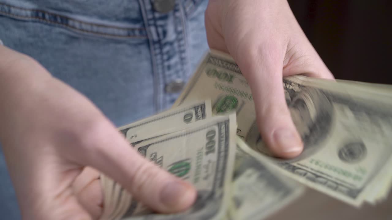 primer plano de manos femeninas contando dólares