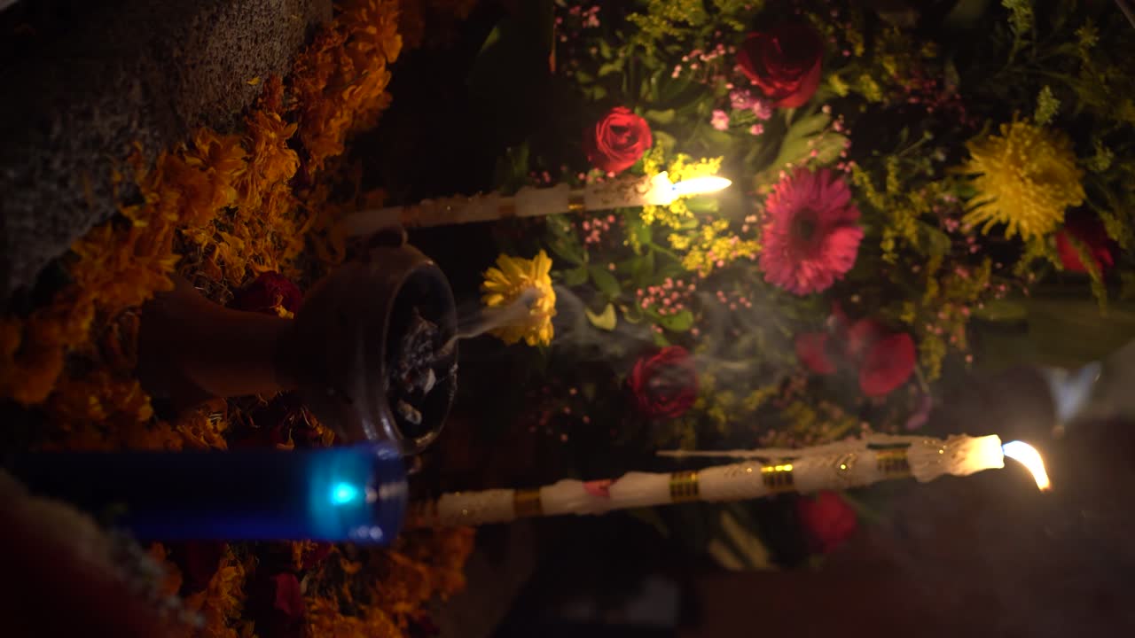 vídeo vertical: ritual con hierbas ardientes, decoración de flores y velas ardientes en el día de los muertos en méxico