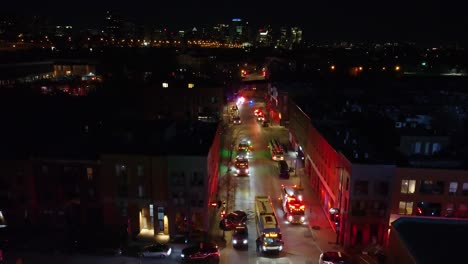coches de policía y camiones de bomberos con luces intermitentes en la calle por la noche