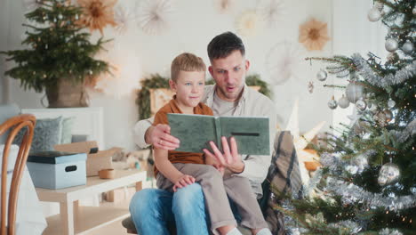 padre y hijo pequeño mirando fotos viejas durante las vacaciones