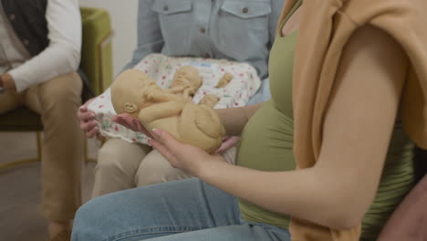 장난감 아기를 들고 임신한 여자