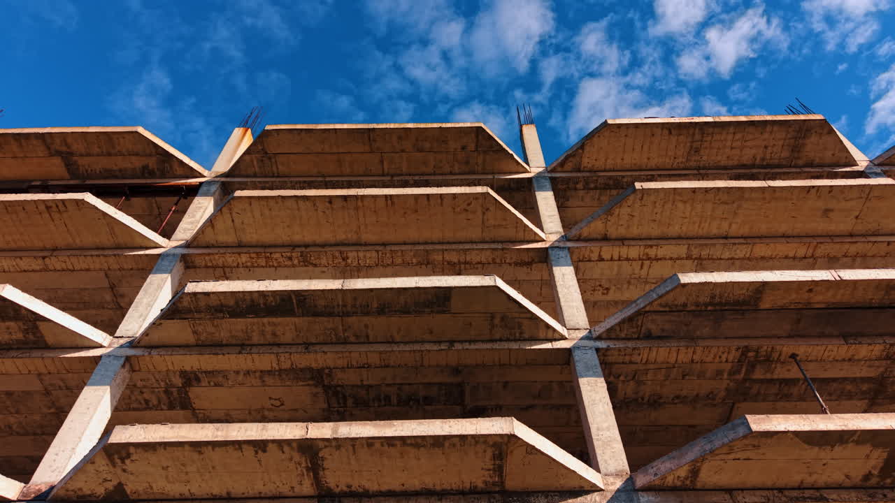 Multi-storied building floors from low angle perspective. Blue sky with light clouds at backdrop