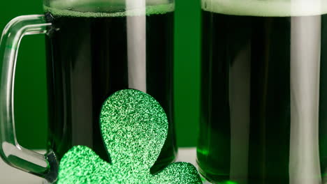 animation of two glasses of beer and clover leaf on green background