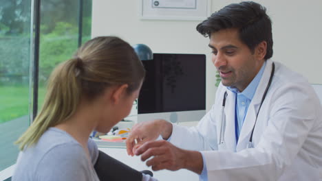 médico masculino o médico de cabecera examinando a una adolescente tomando la presión arterial con un esfigmomanómetro