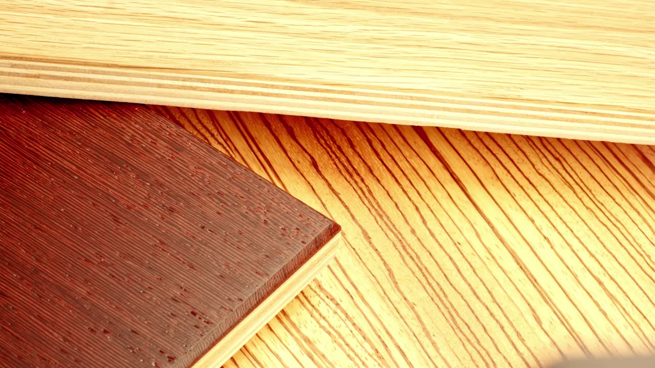 Primo piano di una mano guantata che applica mordente scuro per legno su una tavola di legno