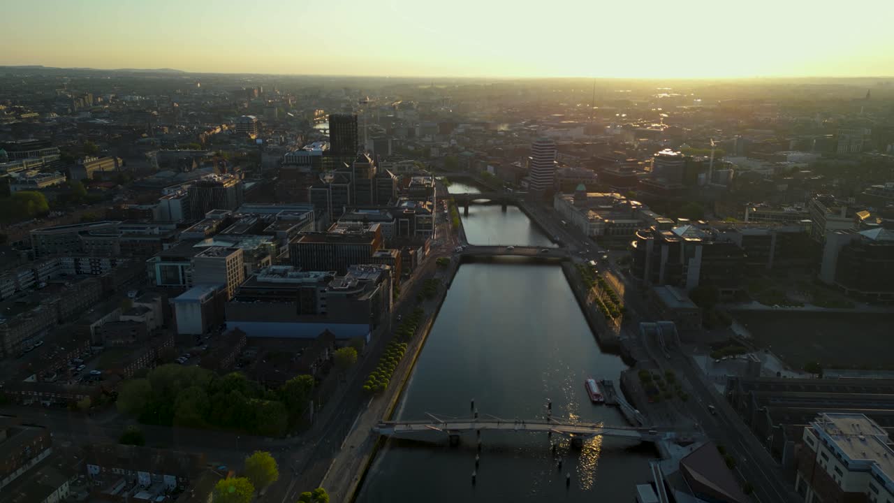 Aerial panoramic view of Dublin City centre - Liffey River surrounded by business buildings during sunset time - Ireland