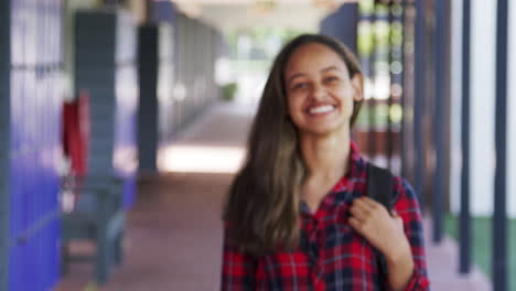 black teenage girl walks into focus in high school corridor