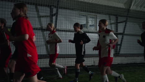 equipo de fútbol femenino corriendo durante el entrenamiento en interiores