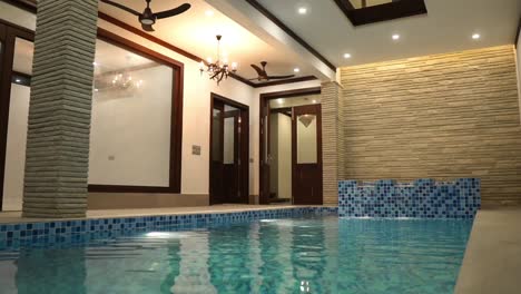 low angle view of indoor swimming pool in luxury home with blue white tiling