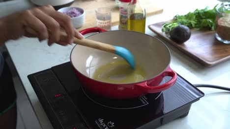 mezclar aceite de oliva caliente en una sartén prepararse para cocinar una comida e ingredientes especiales para cocinar la comida dos latas de frijoles arroz plátano aguacate cebolla roja y cilantro