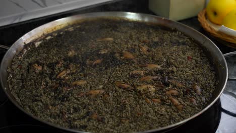 delicioso plato de paella con arroz y tinta de calamar en la sartén de paella, de cerca