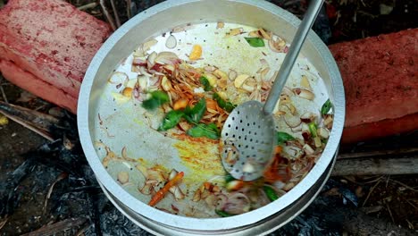 el polvo de cúrcuma se añade a la cebolla, el jengibre y los chiles verdes, el curry de masala de almeja negra, el almuerzo tradicional al aire libre, la cocina de almejas negras, la contaminación, el masala, el ladrillo