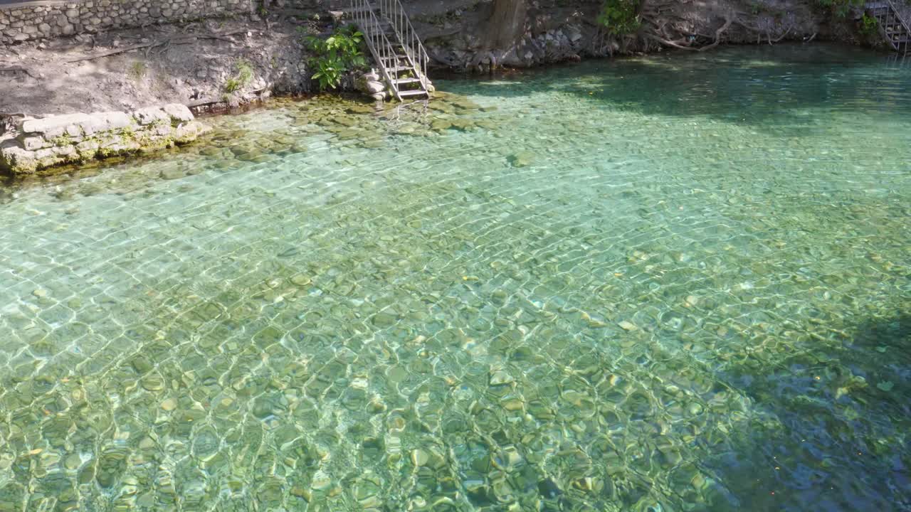 Sfondo astratto di luce solare che crea pattern caustici sulla superficie increspata di un fiume cristallino a Las Marias, Repubblica Dominicana