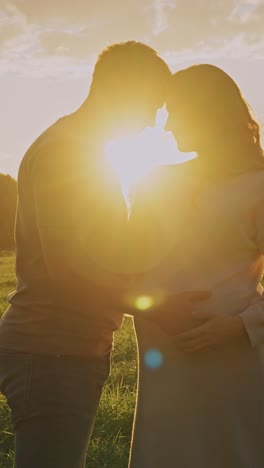 pregnant couple at sunset
