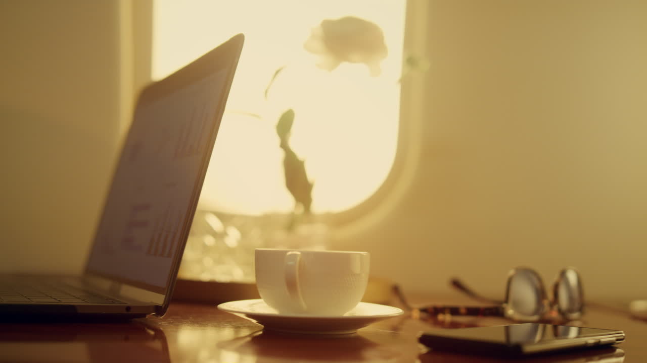 재무 관리자가 차트를 클로즈업하고 있습니다. 손은 비행기에서 노트북 컴퓨터를 타이핑하고 있습니다.