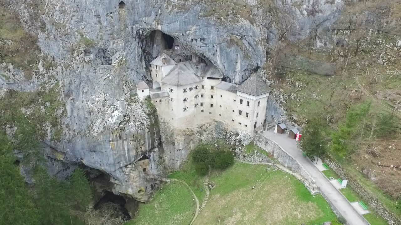 toma de drones del misterioso castillo de predjama, construido en la boca de una cueva en las montañas de eslovenia.