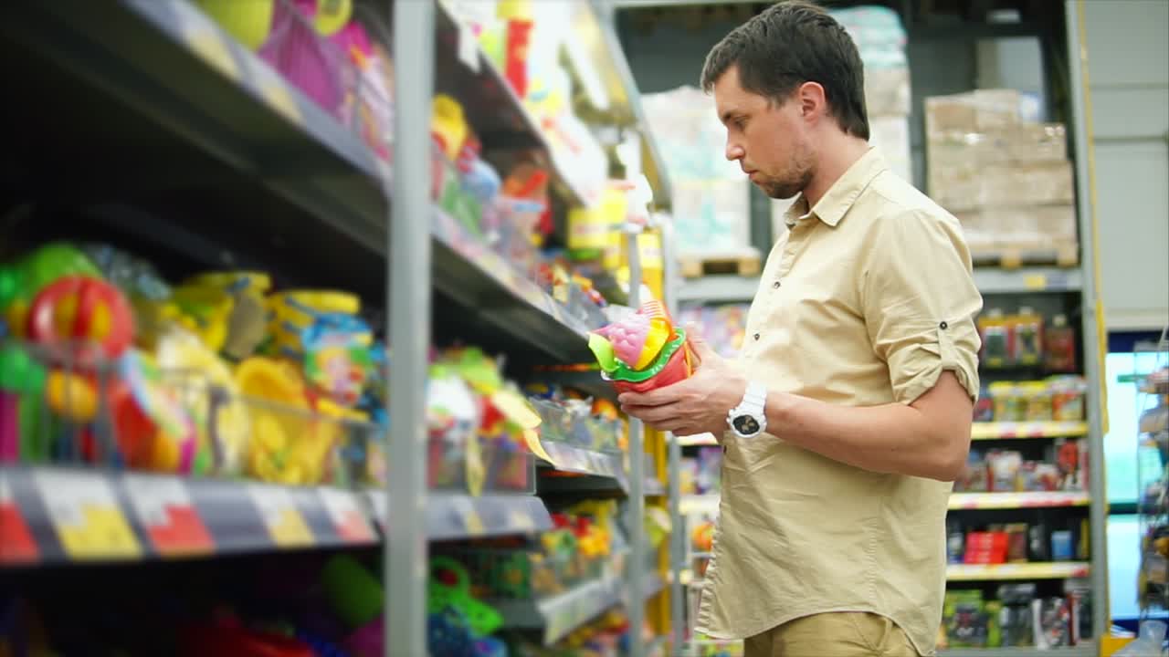 hombre comprando juguetes de playa en un supermercado