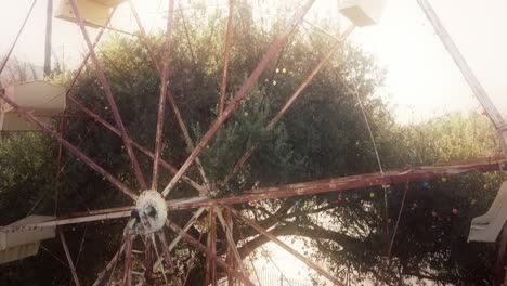 Antena-Ascendente-Sobre-Una-Noria-Abandonada-En-Una-Colina-Con-Palmeras