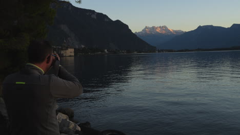 hombre de mediana edad fotografía el castillo de chillon en suiza y durante la hora dorada