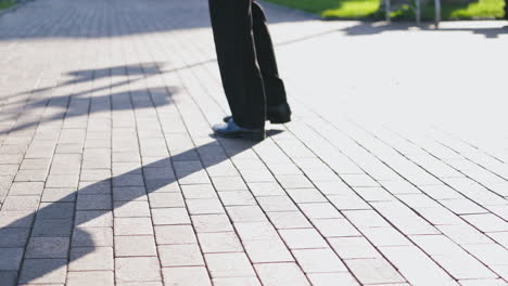 Feet of the businessman walking outdoors. Legs of a man in black trousers and shoes walking nervously up and down the street. Close-up.